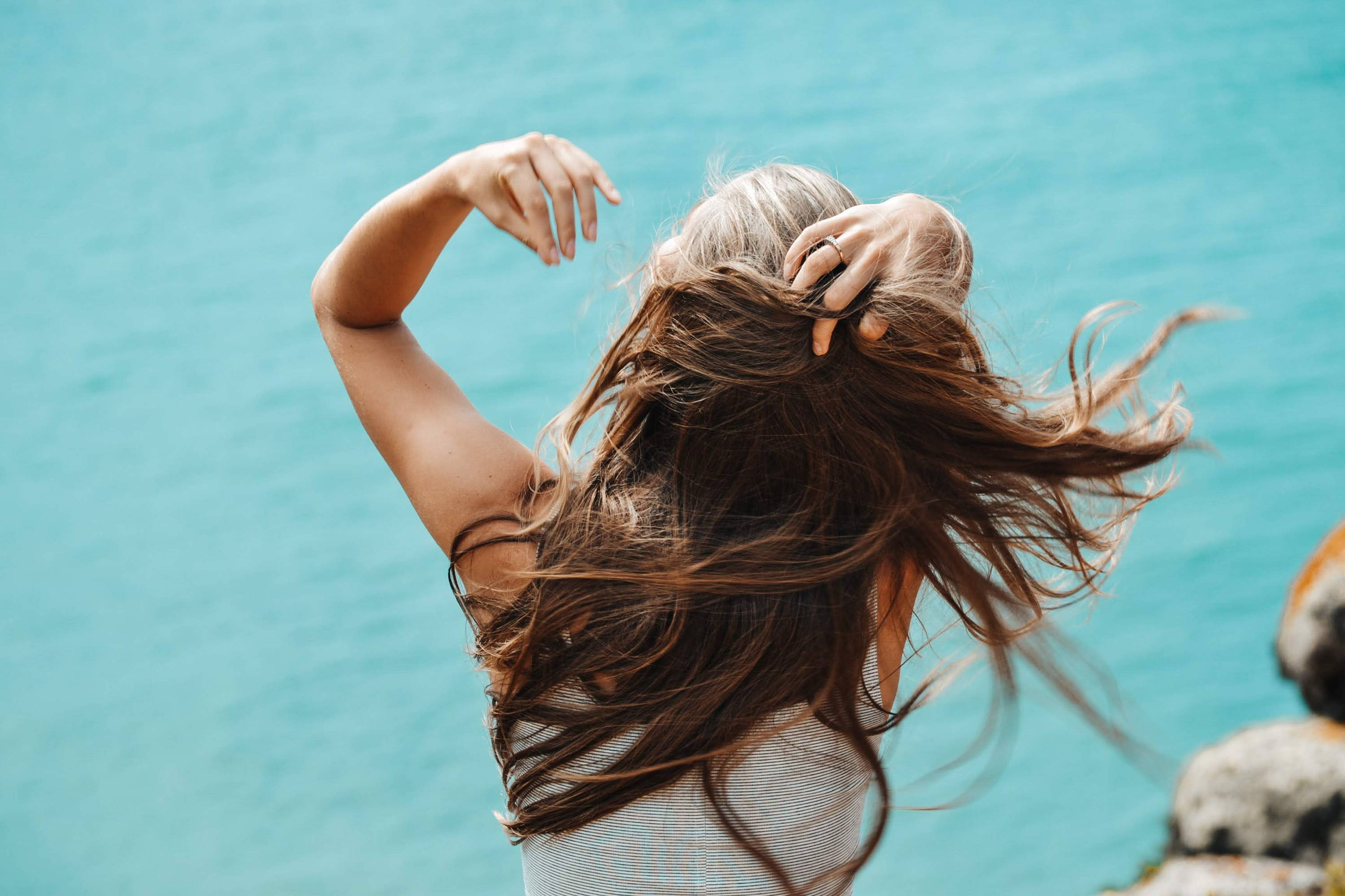 Femme avec de beaux cheveux longs avec une vue sur la mer